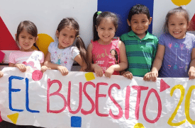 El Busesito IDEAS Impact girls with banner